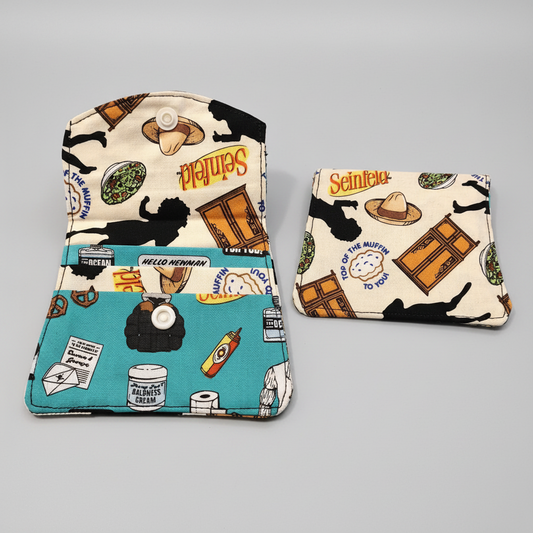 Two fabric pouches with SeinFeld-themed designs on a gray background