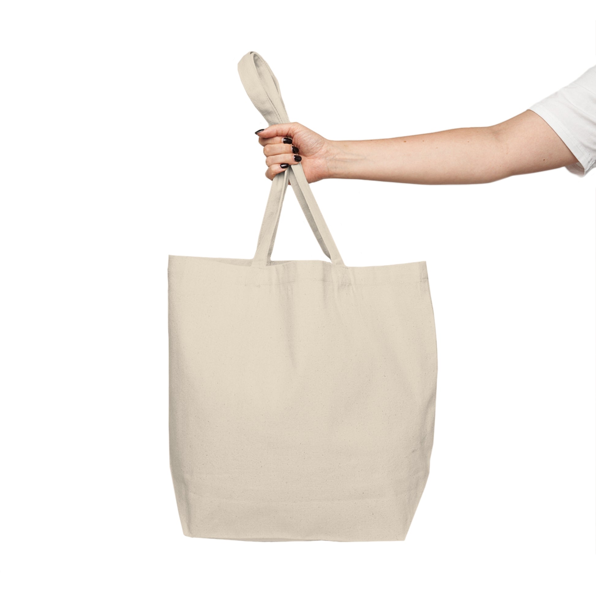 Beige tote bag held by a hand on a white background