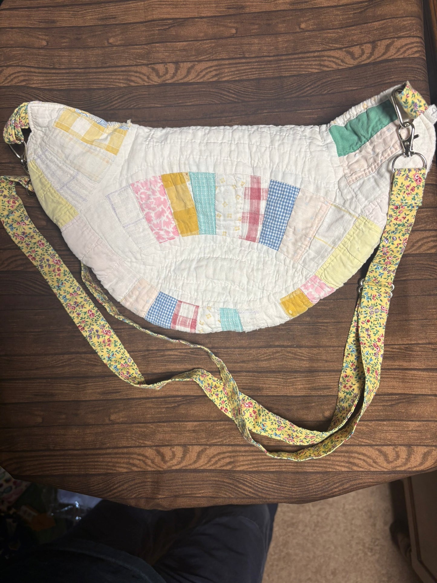 Patchwork bag with a floral strap on a wooden surface