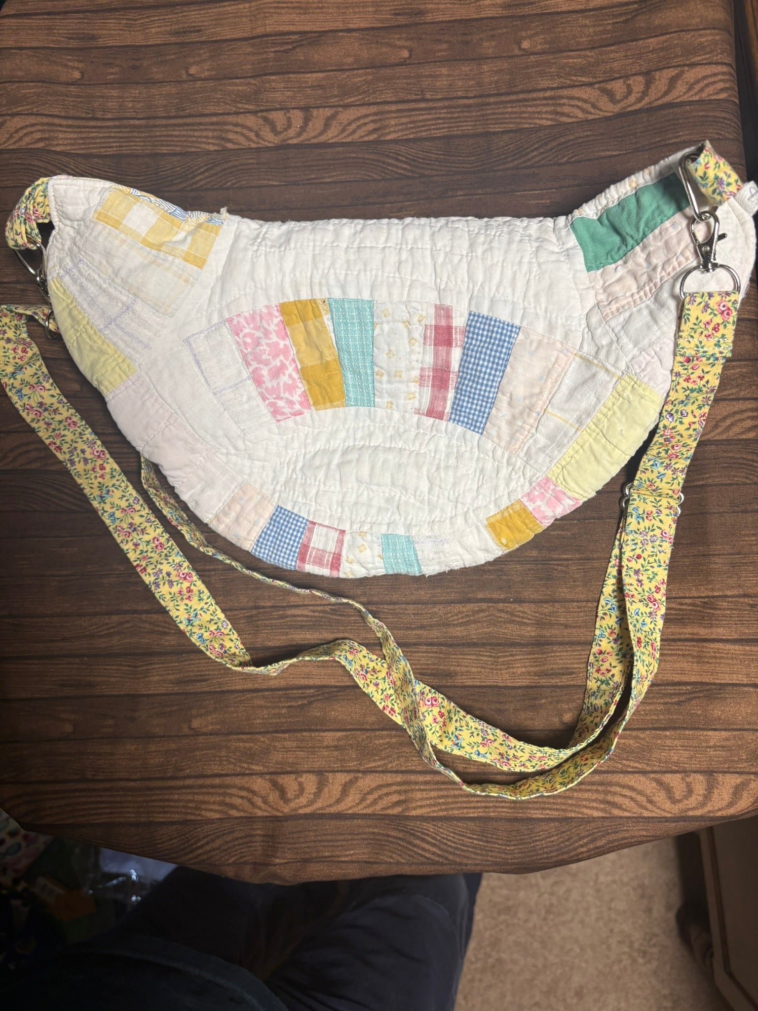 Patchwork bag with a floral strap on a wooden surface