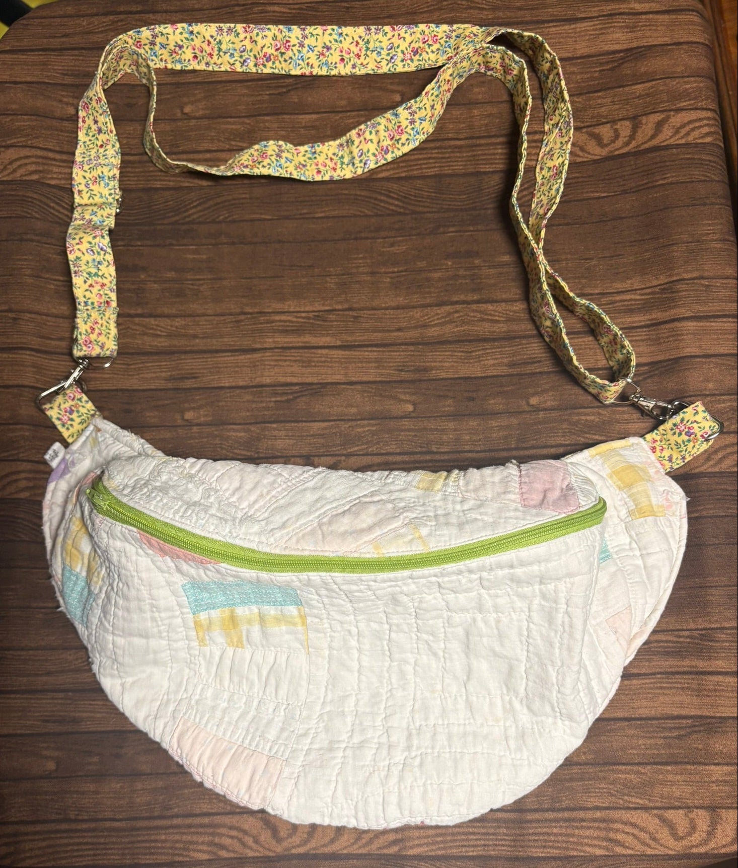 White bag with a floral strap on a wooden surface