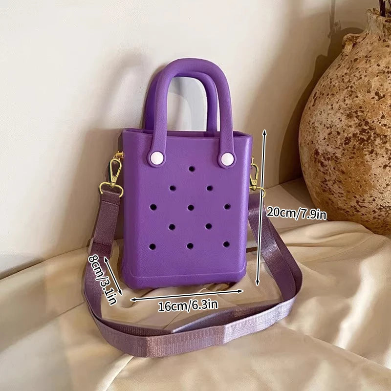 Purple handbag with measurements on a beige surface