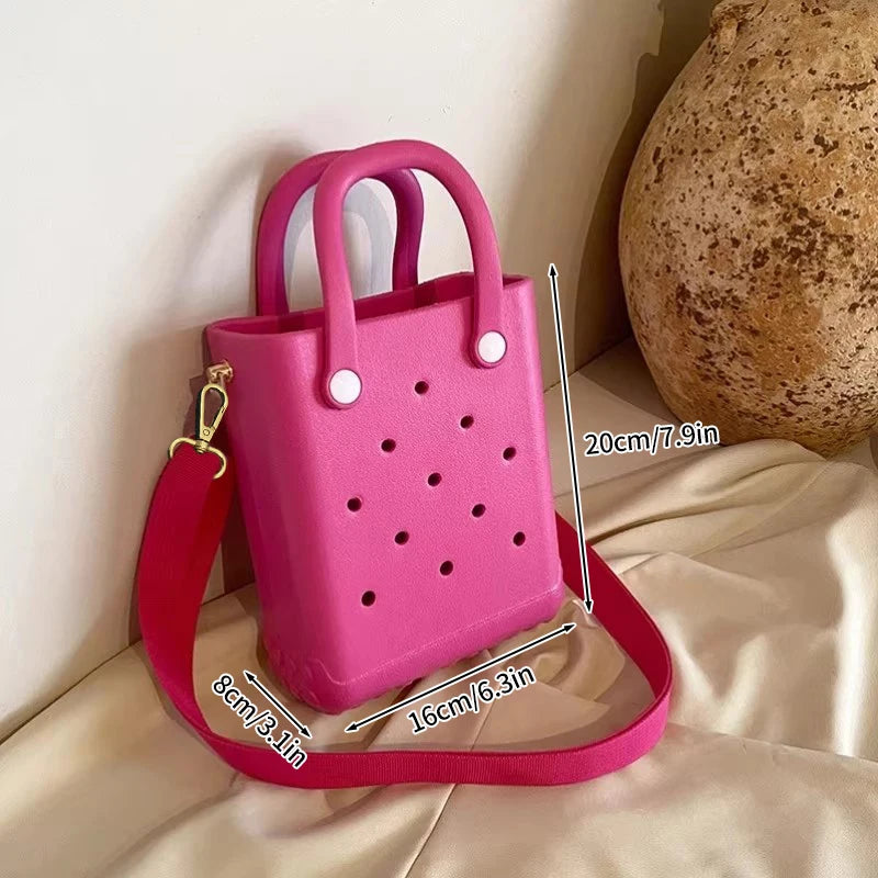 Pink handbag with measurements on a beige surface