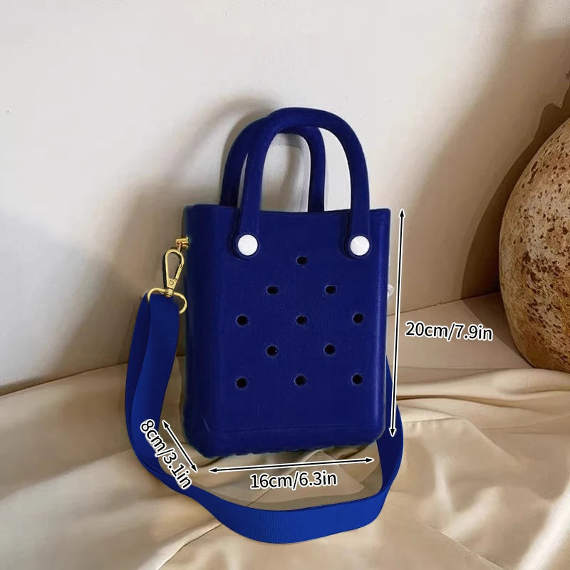 Blue handbag with measurements on a beige surface