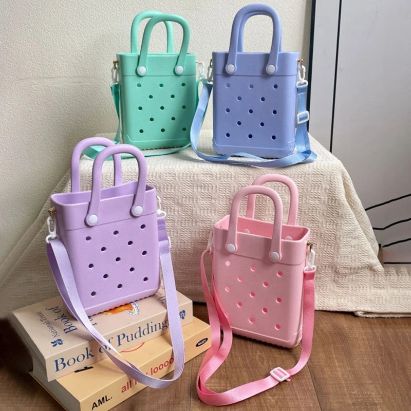 Four colorful handbags on a wooden surface with a neutral background